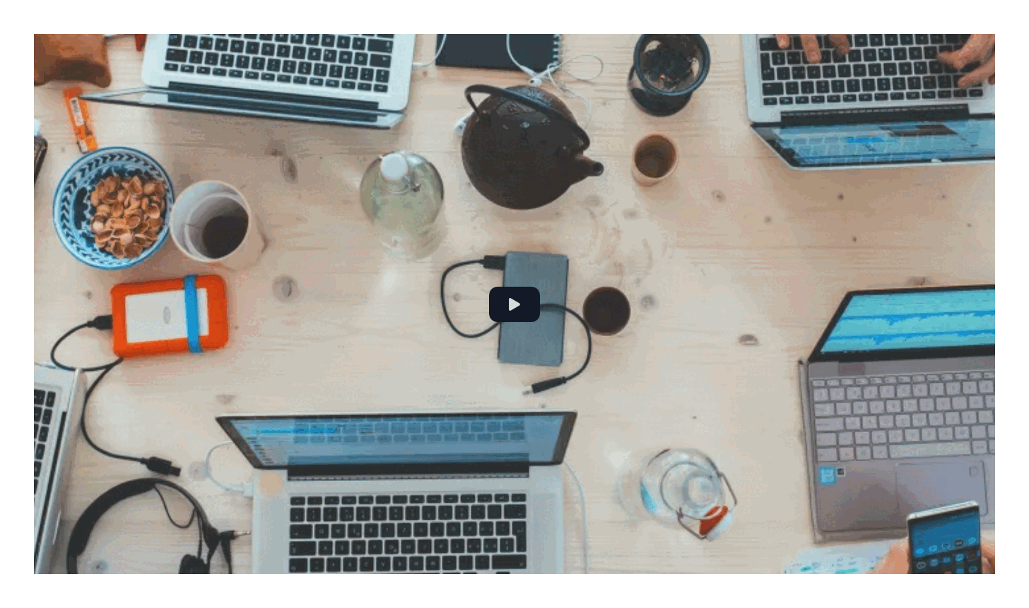 Video with a cover photo of laptops on a desk and a themed play button